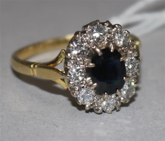An 18ct gold, sapphire and diamond set oval cluster ring, size R.